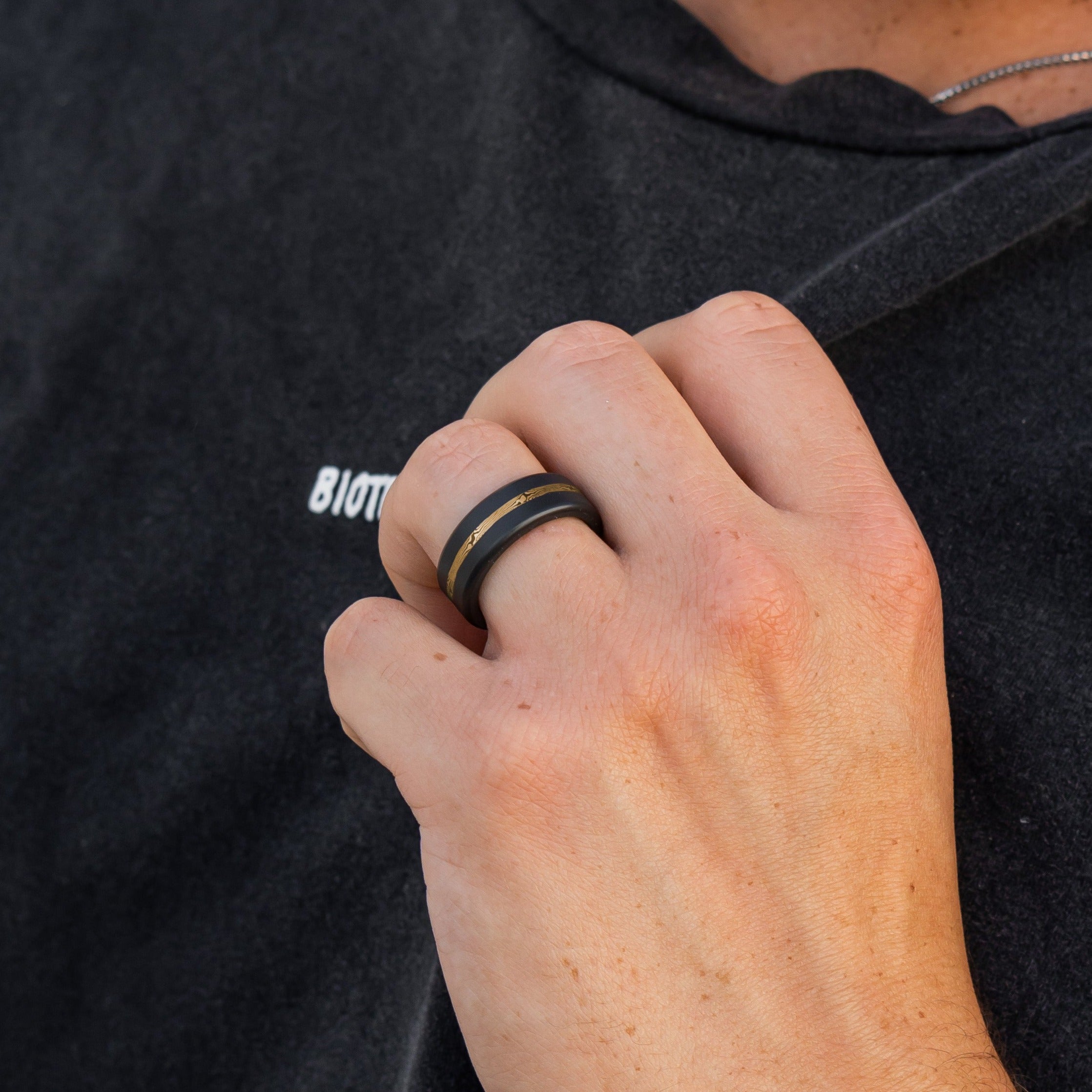 Lifestyle shot #2 of men's hands wearing our Elysium ARES Men's Black Diamond & Mokume 14k Gold Inlay | ElysiumBlack.com | Men’s Mokume Gold Wedding Rings