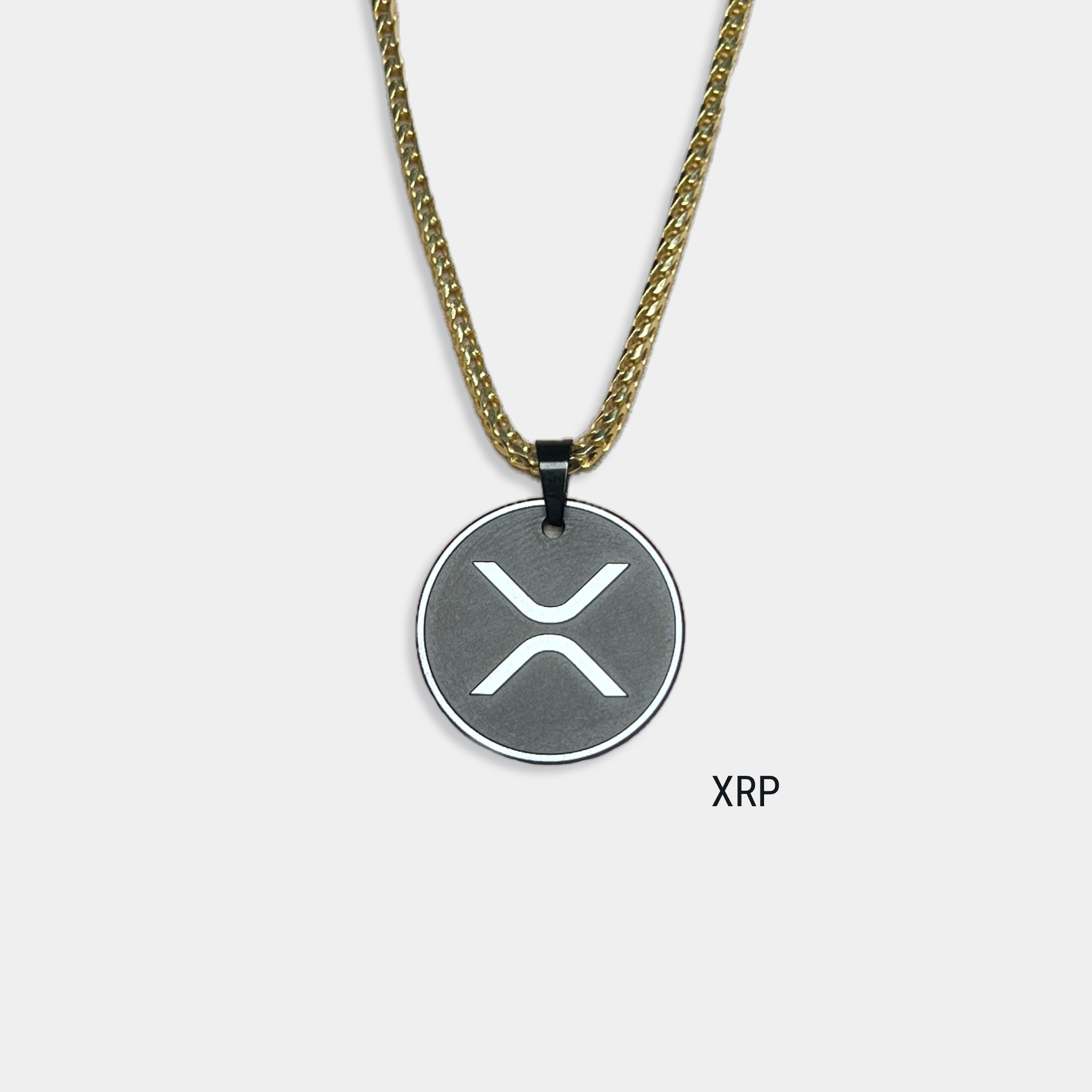 Photo of round solid black diamond pendant with xrp symbol engraved, attached to gold chain